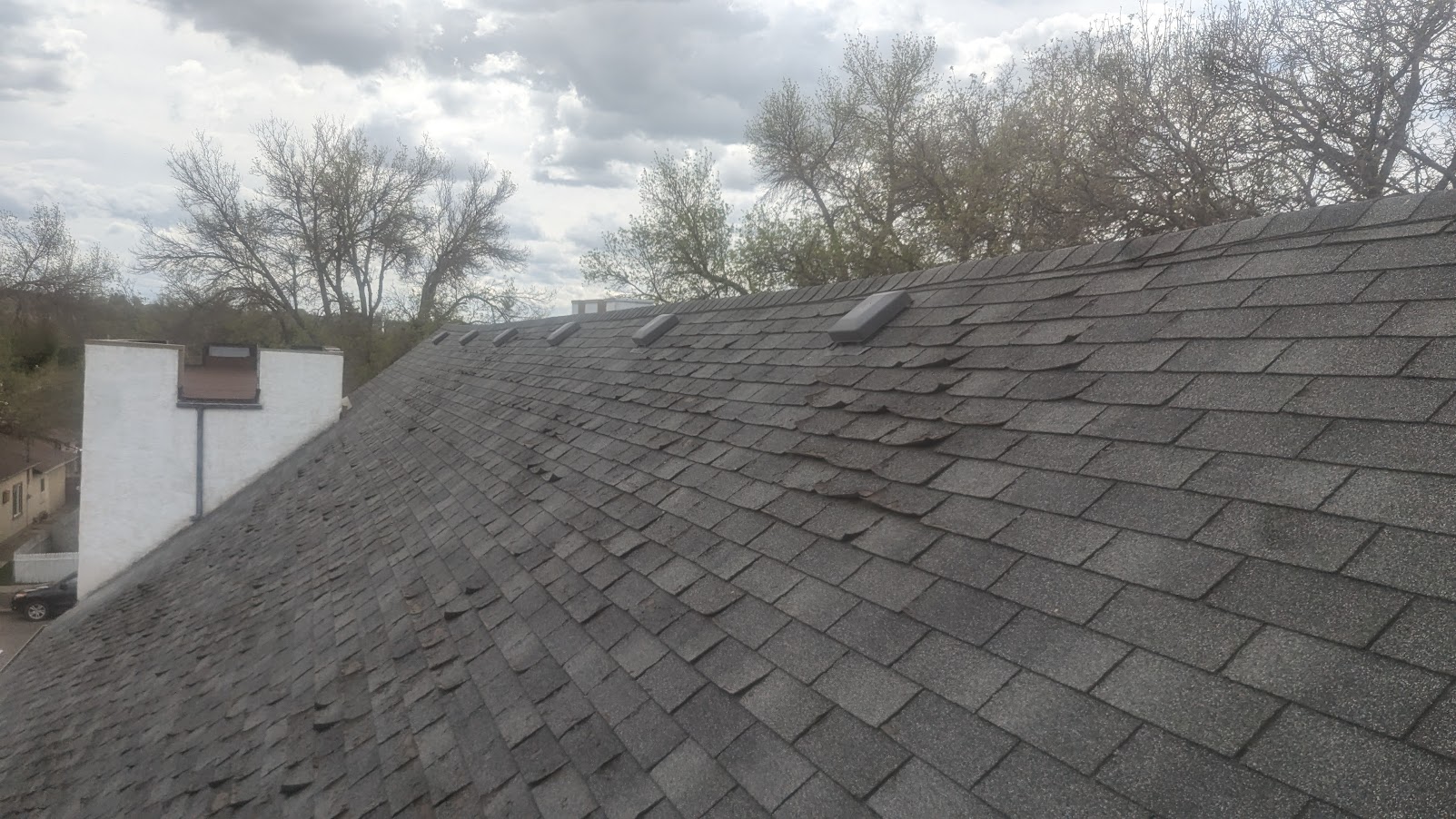 Belfast roof with worn and lifted asphalt shingles before replacement