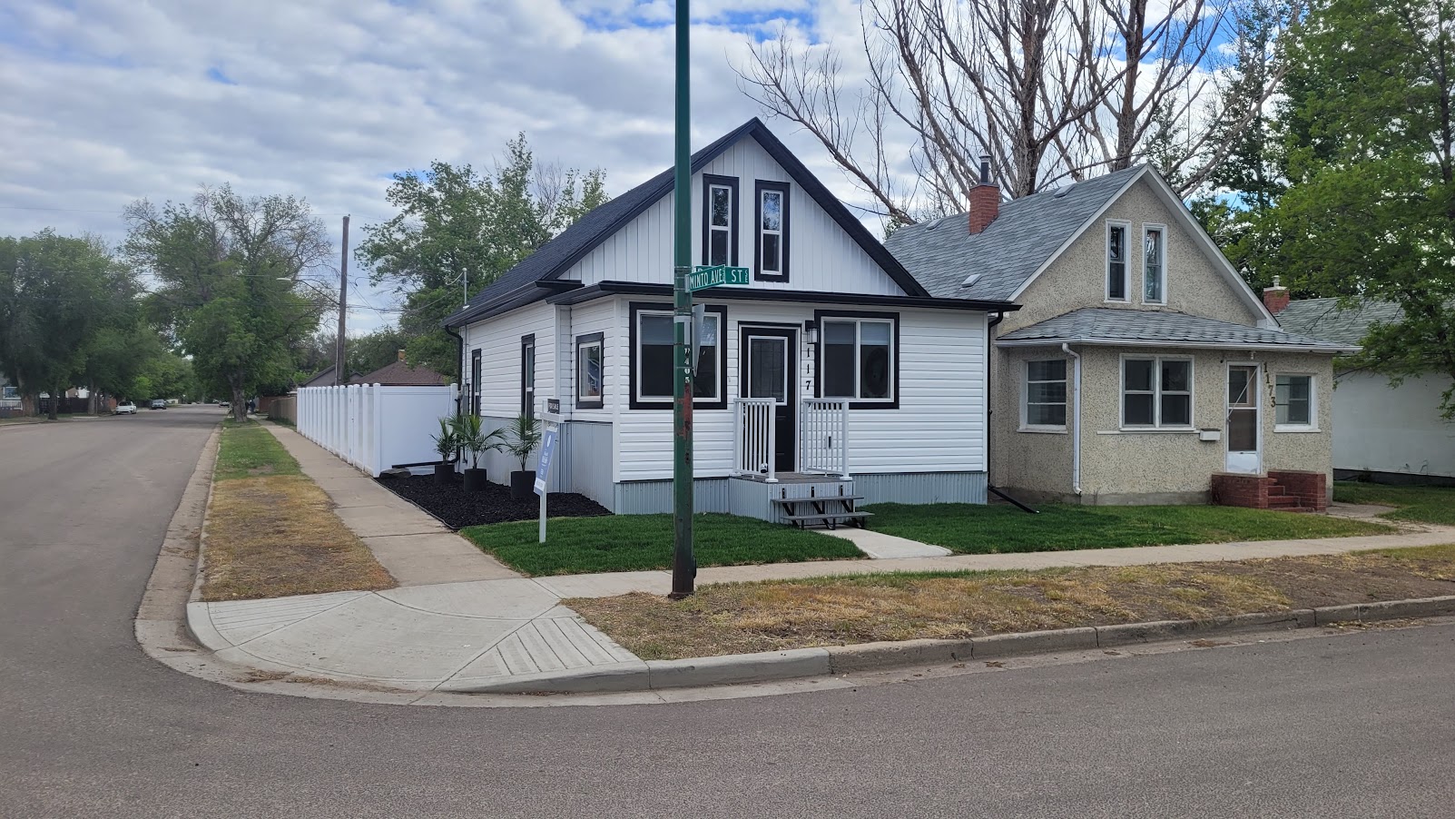 Completed white siding and black trim exterior renovation on Minto Avenue
